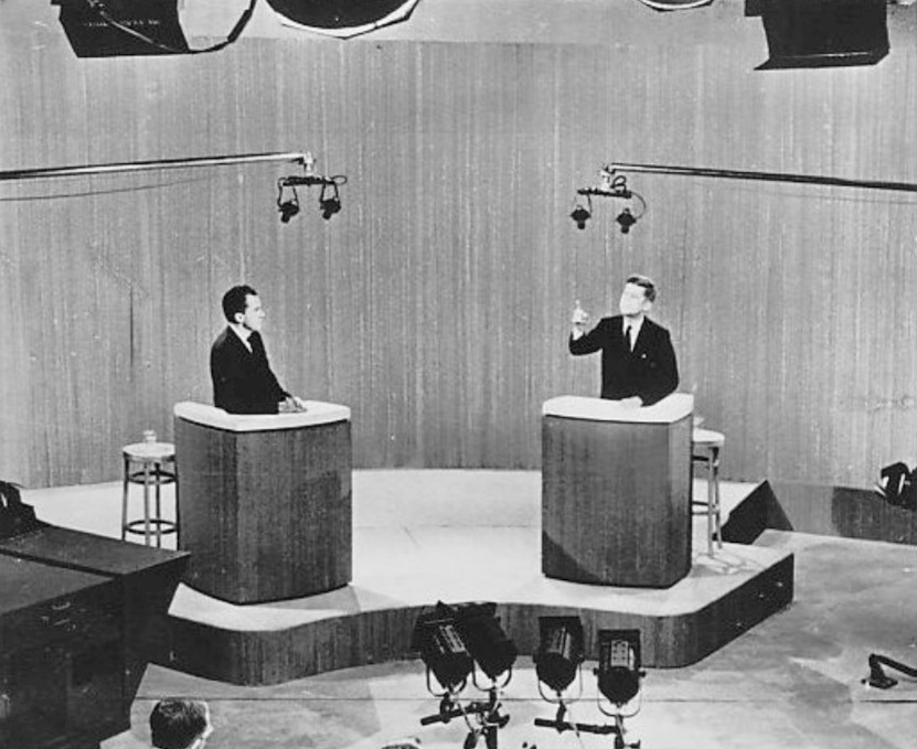 John F. Kennedy gestures while Richard Nixon listens during a televised presidential debate in 1960.