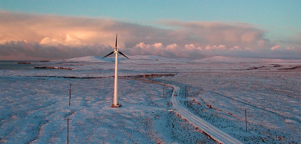 A wind turbine beside a coastal community in Alaska