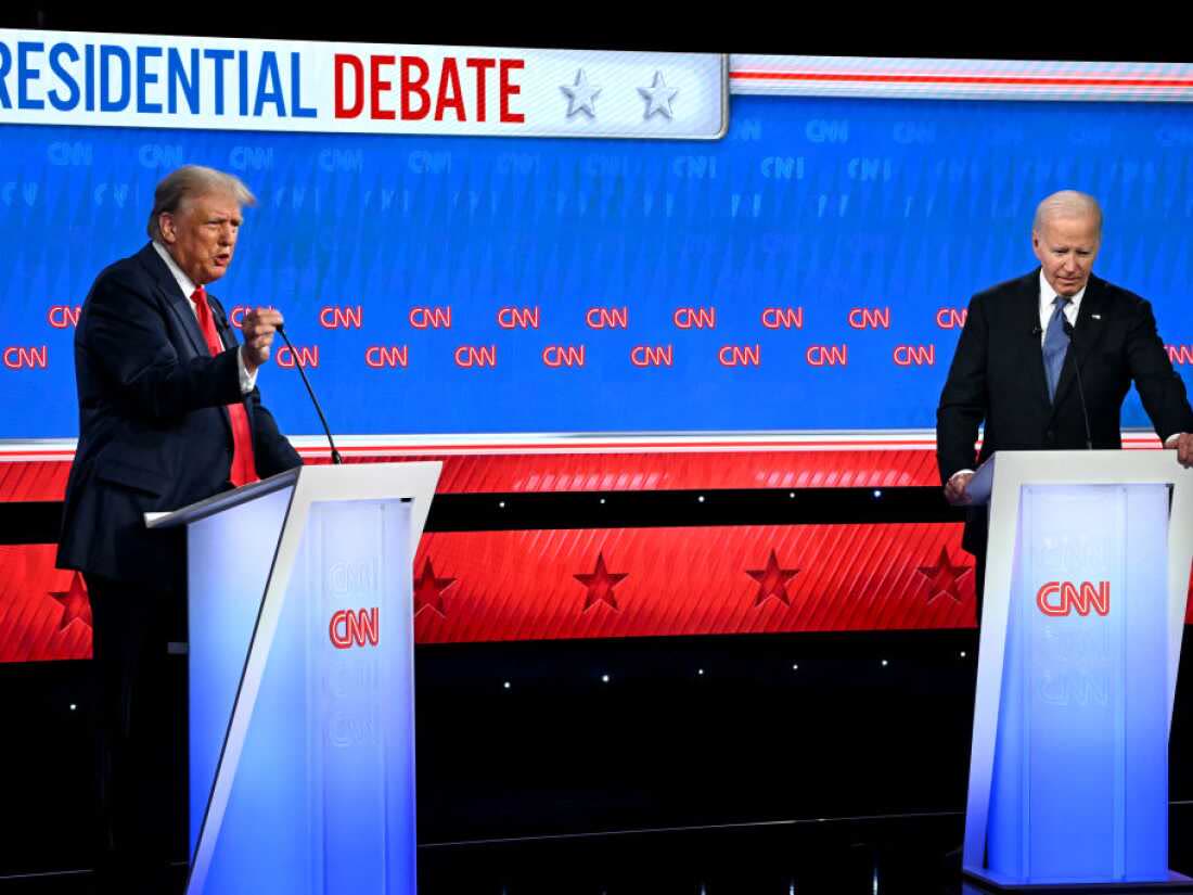 Two candidates at podiums on a televised presidential debate stage